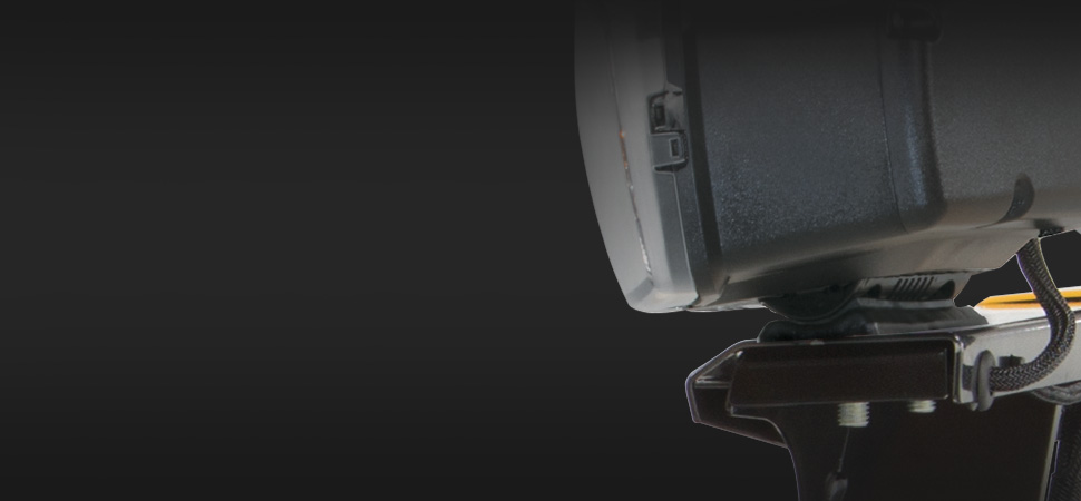 A close-up view of a mounted black electronic device, possibly a sensor or smart camera, against a dark background. Only part of the device is visible on the right side of the image.
