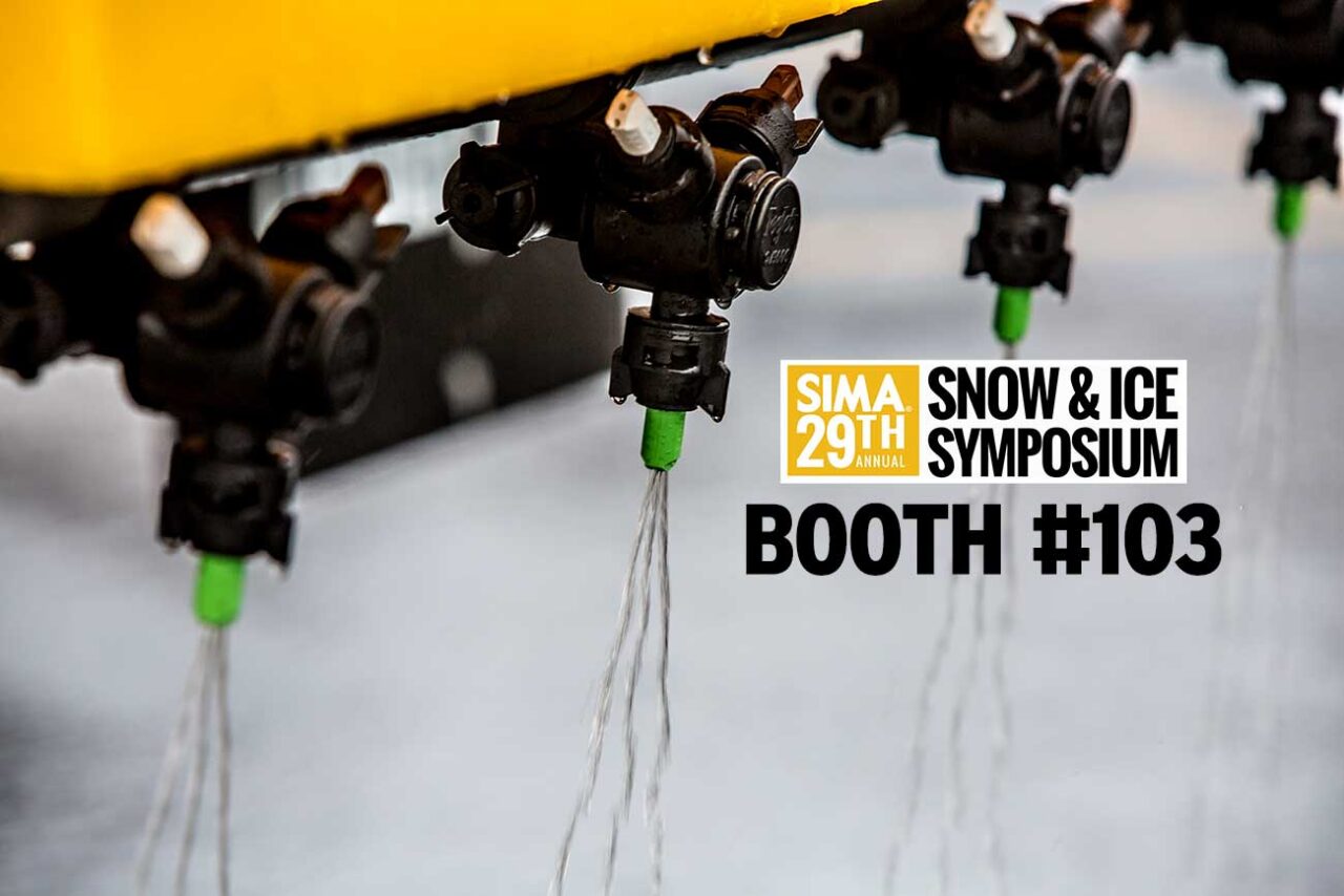Close-up of several black spray nozzles releasing streams of water, with a yellow structure above. Text reads: “SIMA 29th Annual Snow & Ice Symposium Booth #103.”.